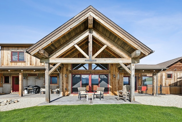 rear view of property featuring a lawn and a patio area