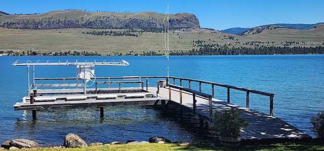 view of dock with a water and mountain view