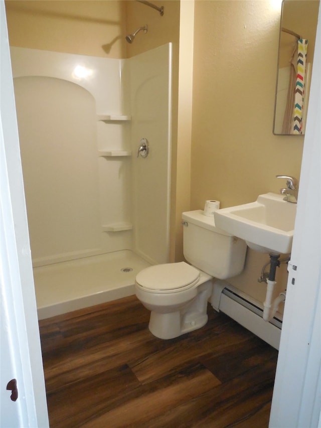 bathroom featuring toilet, sink, hardwood / wood-style floors, a shower, and a baseboard radiator