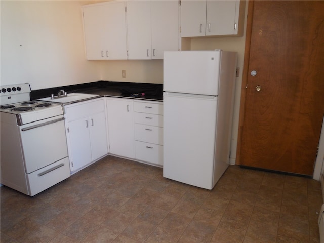 kitchen with dark tile floors, white appliances, and white cabinetry