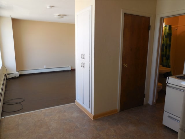 hall with baseboard heating and tile floors