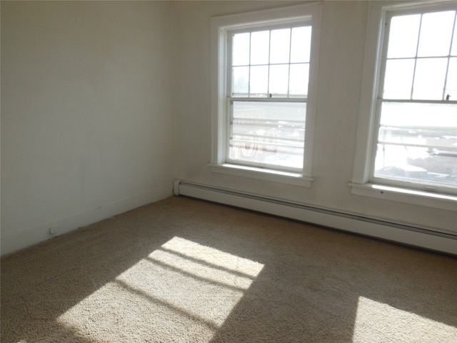 spare room featuring dark carpet and a baseboard radiator