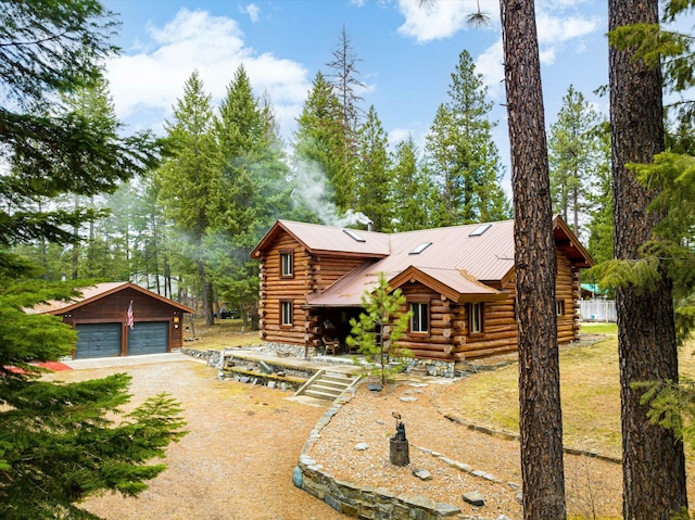 log-style house featuring an outbuilding and a garage