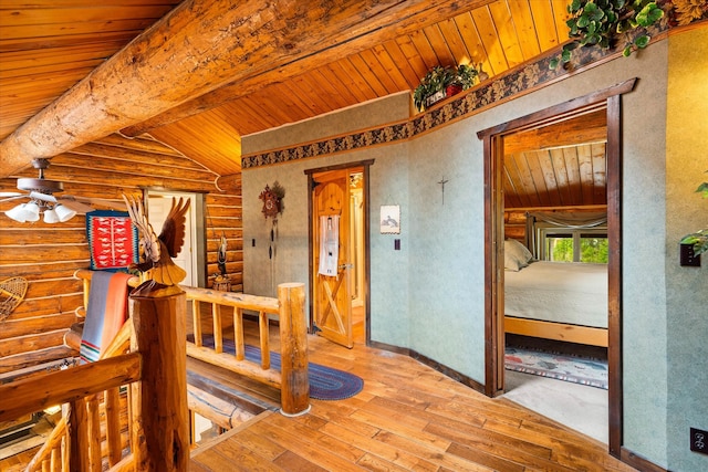 hallway featuring rustic walls, hardwood / wood-style flooring, beamed ceiling, and wooden ceiling