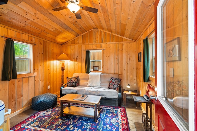 living room featuring wooden walls, light hardwood / wood-style floors, wood ceiling, and lofted ceiling