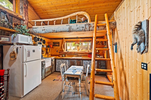 kitchen featuring white appliances, lofted ceiling, carpet floors, wood walls, and wooden ceiling