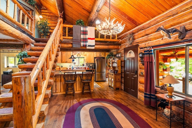 interior space featuring dark wood-type flooring, high vaulted ceiling, a wealth of natural light, wooden ceiling, and an inviting chandelier