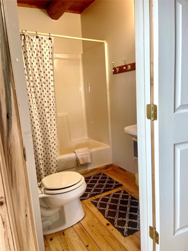 bathroom featuring toilet, shower / tub combo, and hardwood / wood-style flooring