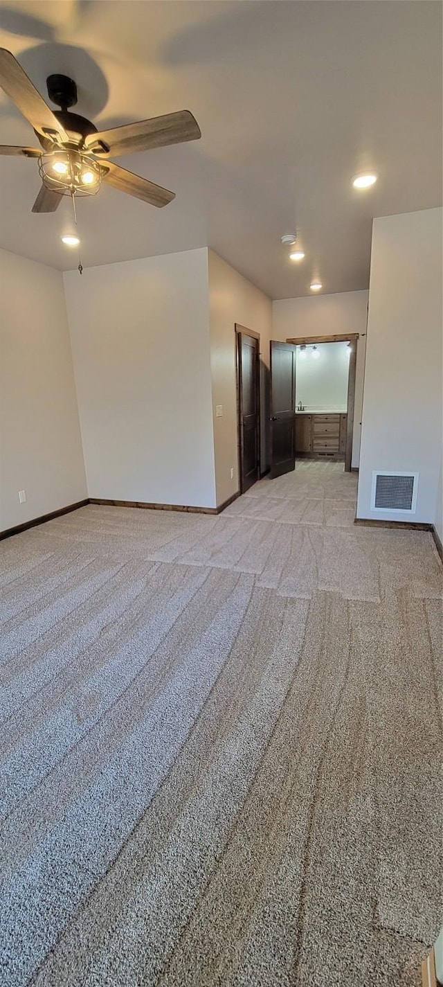 spare room featuring light colored carpet and ceiling fan