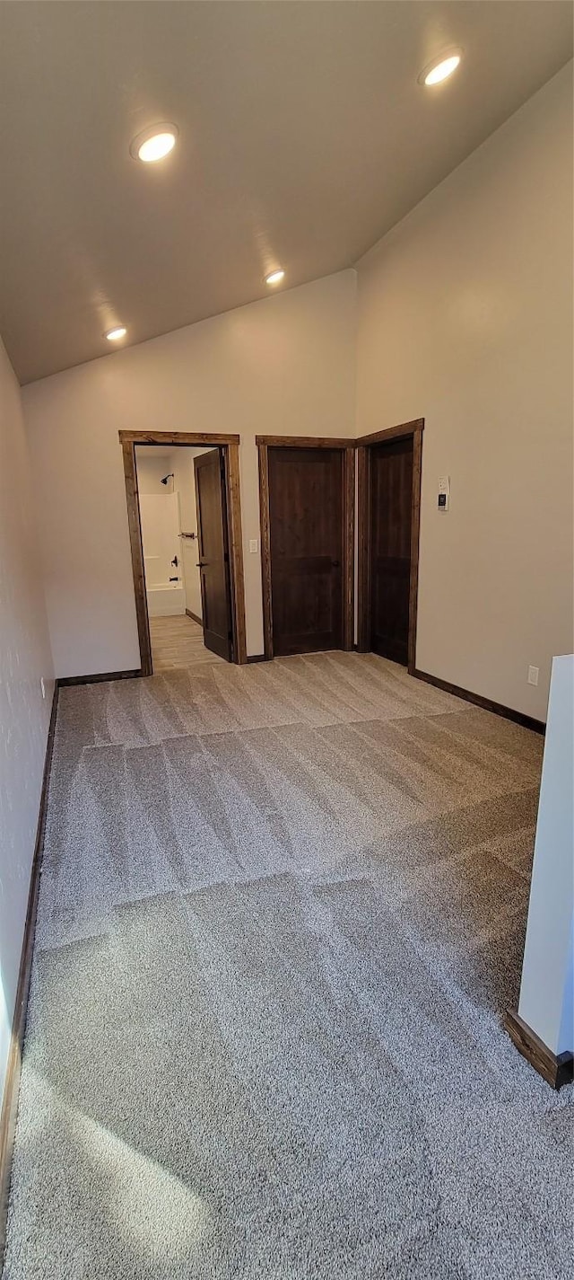 unfurnished bedroom with lofted ceiling and light carpet