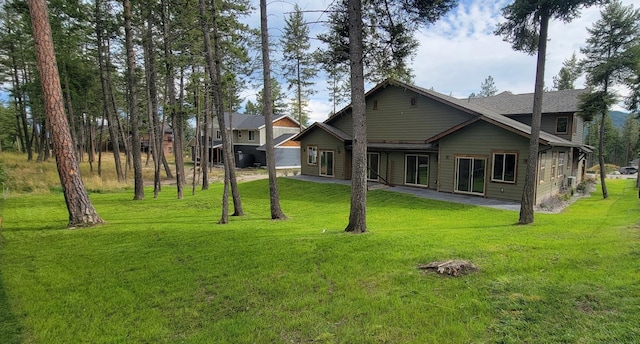 back of house with a lawn and a patio