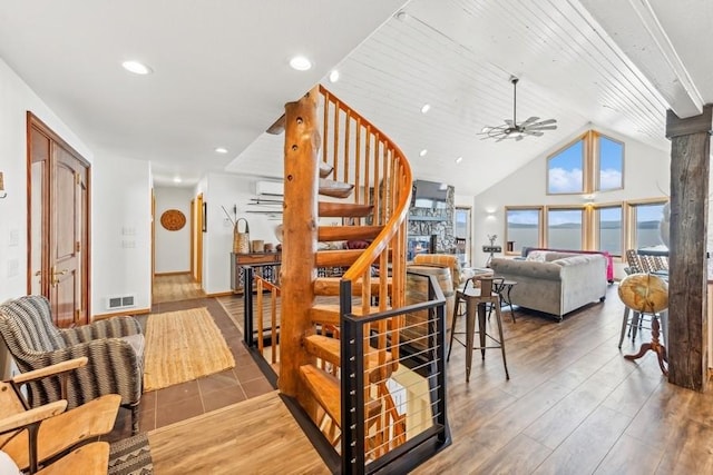 17431 Fishing Rock Ln, Bigfork, MT 59911 - stairway with ceiling fan, wood finished floors, vaulted ceiling, a wall mounted AC, and recessed lighting