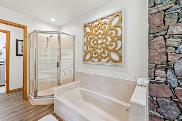 bathroom featuring recessed lighting, a shower stall, a bath, and wood finished floors