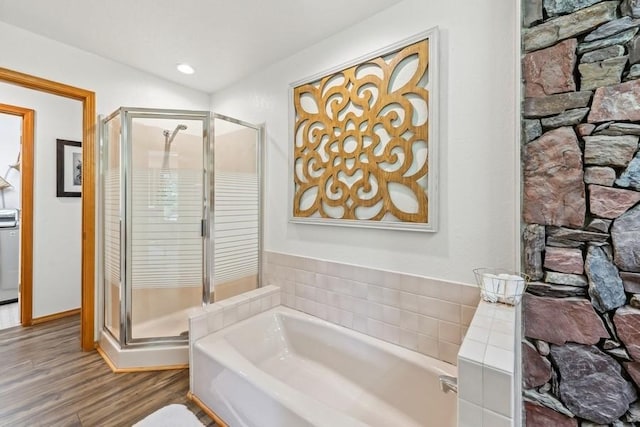 17431 Fishing Rock Ln, Bigfork, MT 59911 - bathroom featuring a garden tub, a stall shower, and wood finished floors