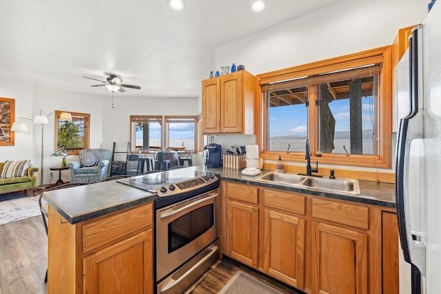 17431 Fishing Rock Ln, Bigfork, MT 59911 - kitchen with stainless steel electric range, freestanding refrigerator, dark wood-type flooring, a peninsula, and dark countertops