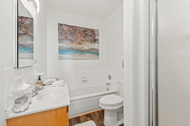 bathroom featuring a garden tub, vanity, wood finished floors, and toilet