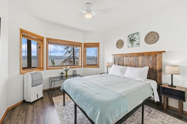 bedroom featuring a ceiling fan, baseboards, and wood finished floors