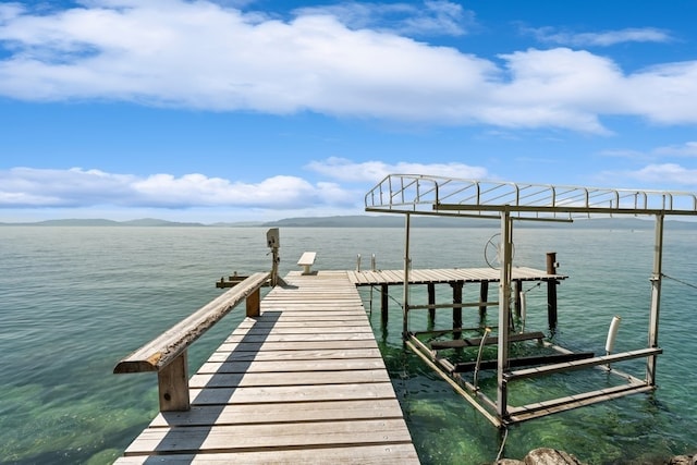 dock area with a water view and boat lift