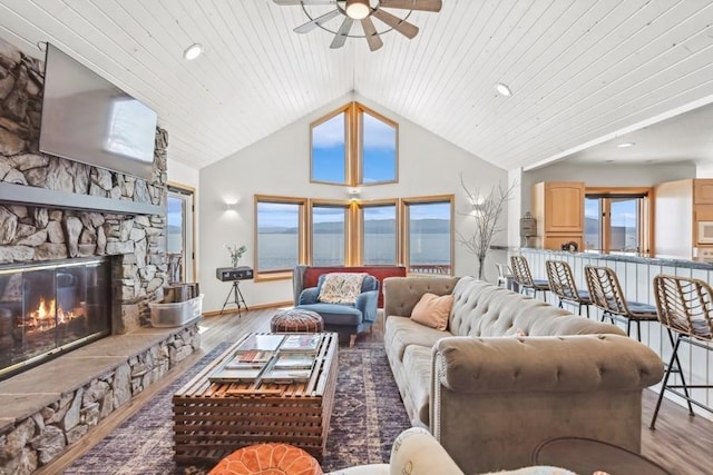 17431 Fishing Rock Ln, Bigfork, MT 59911 - living area featuring ceiling fan, wood finished floors, high vaulted ceiling, a stone fireplace, and recessed lighting