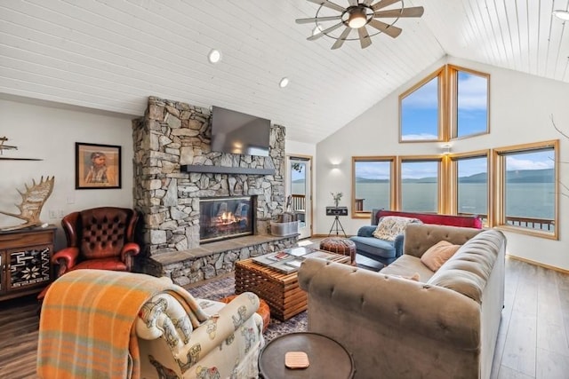 living area featuring wood-type flooring, high vaulted ceiling, ceiling fan, and a stone fireplace