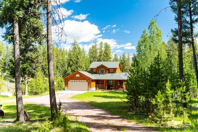 log home with covered porch, a garage, and a front yard