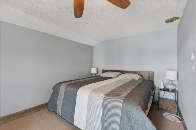 carpeted bedroom with a textured ceiling, lofted ceiling, ceiling fan, and a closet