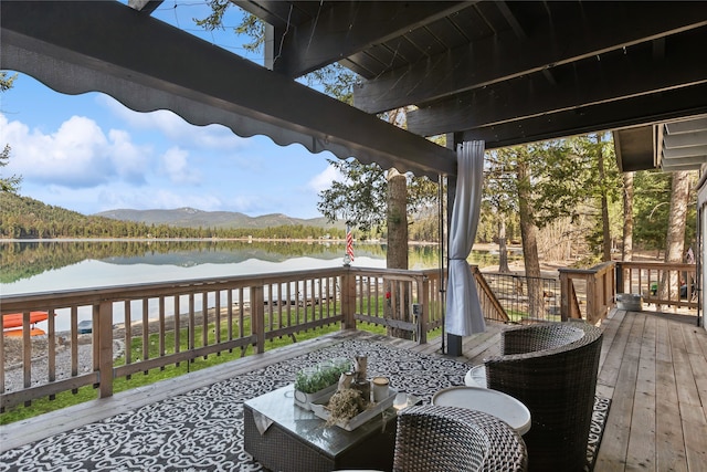 wooden deck with a water and mountain view