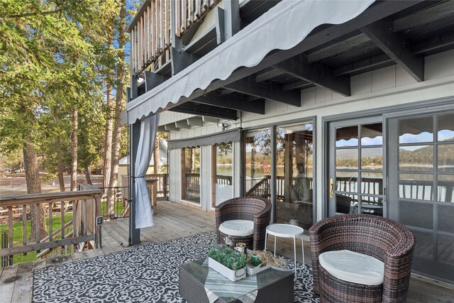 rear view of property with a balcony and a water view