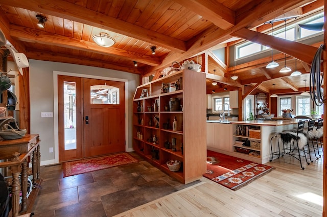 foyer featuring hardwood / wood-style floors, beamed ceiling, and wooden ceiling