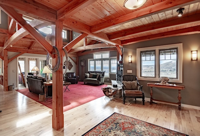 interior space featuring vaulted ceiling with beams, light hardwood / wood-style floors, and wooden ceiling