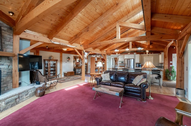 living room with beamed ceiling, high vaulted ceiling, light colored carpet, a fireplace, and wood ceiling