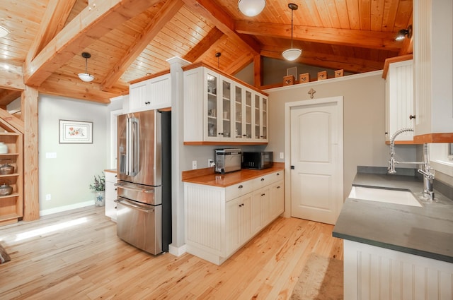 kitchen with white cabinetry, hanging light fixtures, high quality fridge, and sink