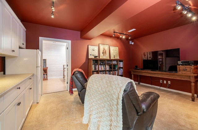 interior space with white refrigerator, light colored carpet, white cabinetry, and track lighting