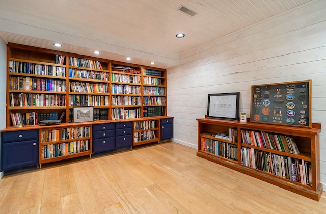 interior space with wooden walls, wooden ceiling, and light wood-type flooring