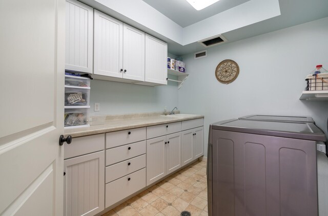 laundry room with cabinets, sink, and washing machine and clothes dryer