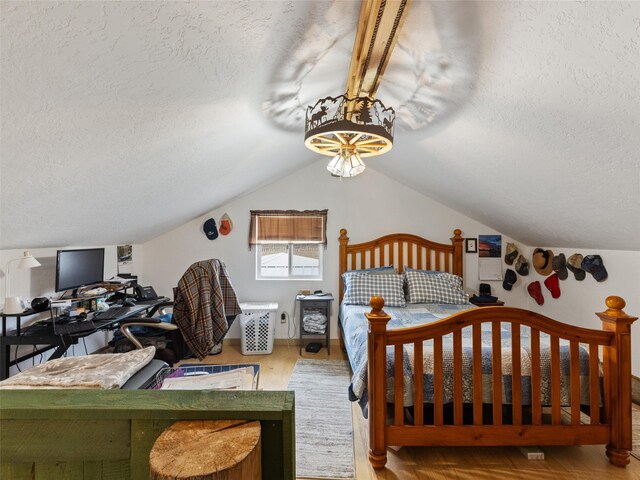 bedroom featuring a textured ceiling, vaulted ceiling, and light wood-type flooring