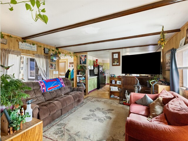 living room featuring beamed ceiling and wood walls