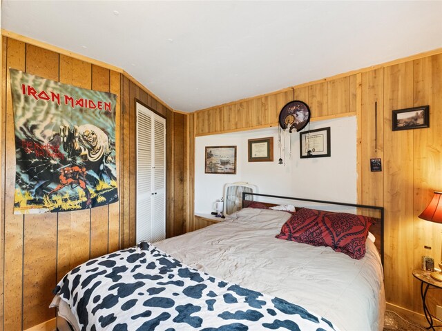 bedroom with wood walls and a closet