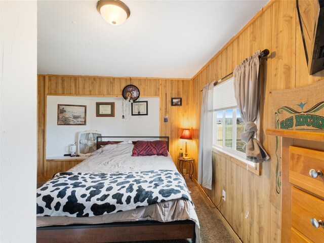 bedroom with carpet flooring and wooden walls