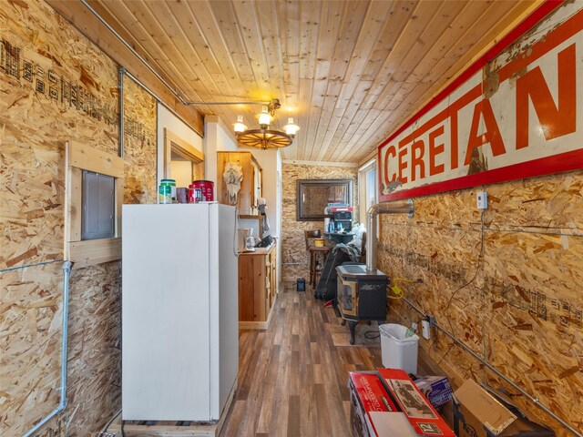 interior space featuring white fridge, a wood stove, dark hardwood / wood-style flooring, wood ceiling, and a chandelier