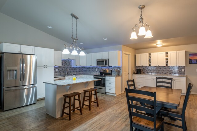 kitchen with backsplash, appliances with stainless steel finishes, and white cabinets