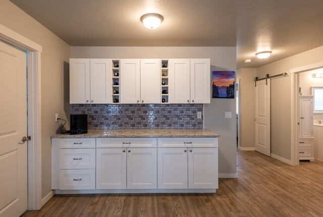 kitchen with white cabinets, tasteful backsplash, and dark hardwood / wood-style flooring