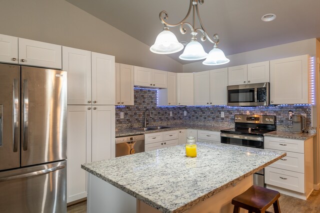 kitchen with stainless steel appliances, white cabinets, and backsplash