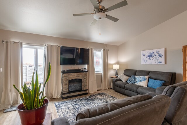 living room featuring a fireplace, ceiling fan, and light hardwood / wood-style flooring