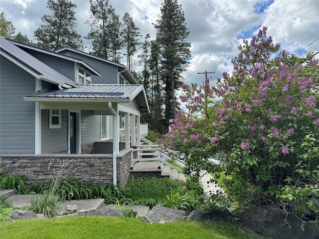 view of side of home with stone siding and metal roof