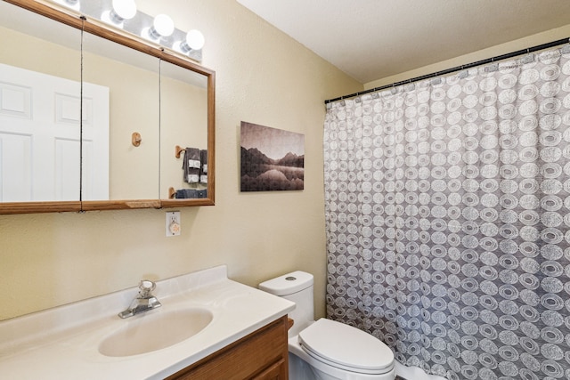 bathroom featuring vanity, a textured ceiling, and toilet