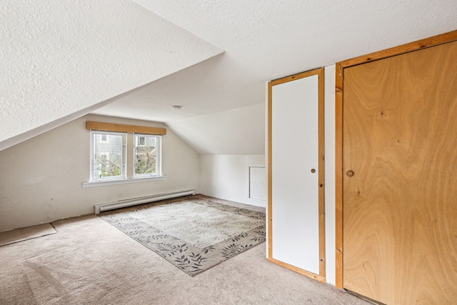 bonus room featuring a textured ceiling, lofted ceiling, light colored carpet, and a baseboard heating unit