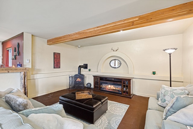 living room featuring beam ceiling and a wood stove
