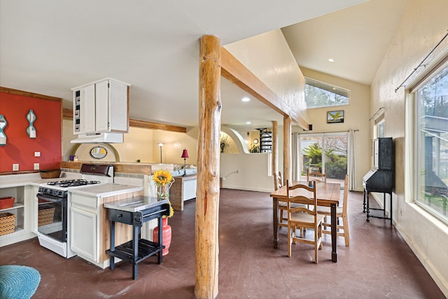 kitchen featuring white cabinets, vaulted ceiling, and gas range gas stove