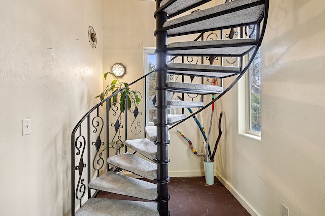 stairs featuring baseboards and a textured wall
